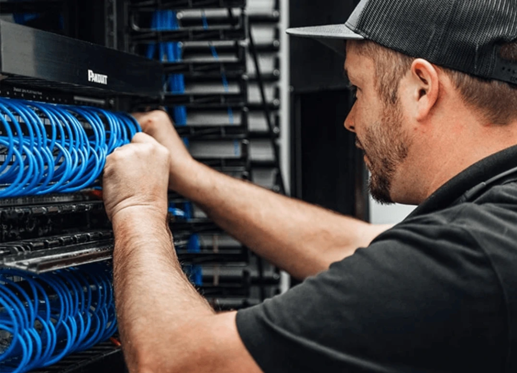 structured-cabling-vancouver-network-rack-installation-wicks-electric Technician installing structured cabling and network rack with patch panel in Vancouver for reliable commercial data infrastructure by Wicks Electric